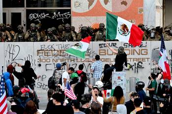 Policías montan guardia frente al Edificio Federal mientras continúan las protestas en respuesta a las operaciones federales de inmigración en Los Ángeles. · Foto: Robyn Beck, AFP
