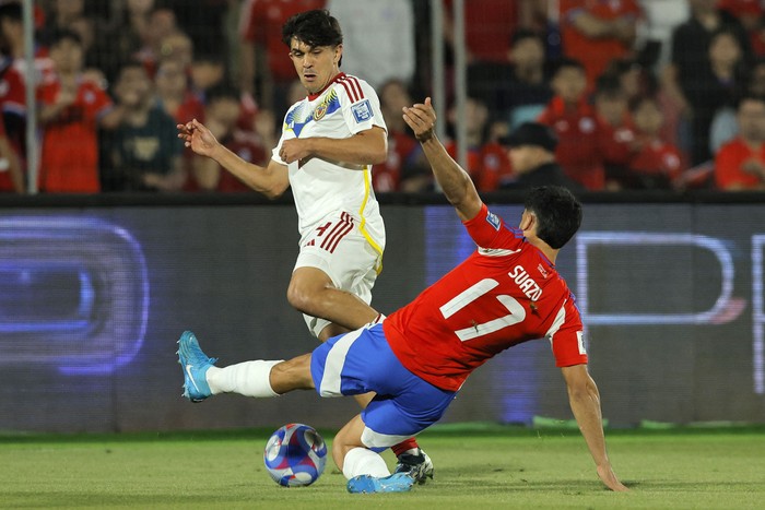 El venezolano Jon Aramburu y el chileno Gabriel Suazo durante el partido de las eliminatorias sudamericanas, este martes, en el Estadio Nacional de Santiago. · Foto: Javier Torres AFP