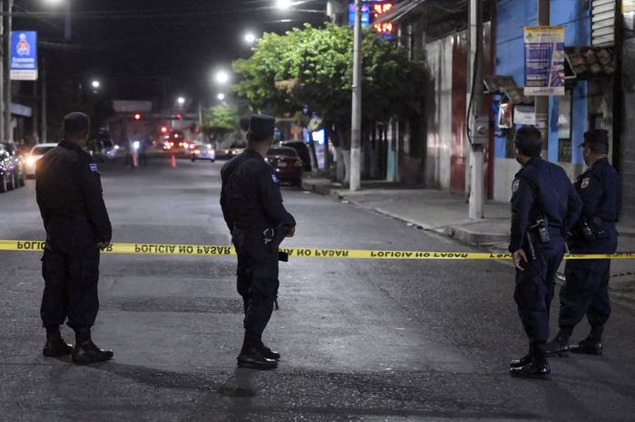 Policías en el lugar donde un hombre fue asesinado por presuntos pandilleros, el sábado, en Colón, departamento de La Libertad, El Salvador. · Foto: Marvin Recinos / AFP