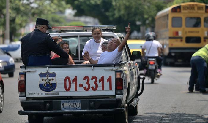 Personas detenidas por presuntos vínculos con pandillas, son trasladas por la Policía Nacional Civil durante el estado de emergencia, el 22 de abril, en San Salvador. · Foto: Marvin Recinos / AFP