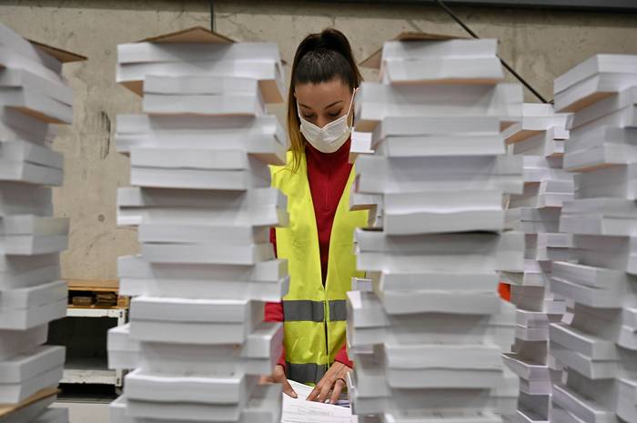 Una operaria organiza parte del material destinado a las elecciones autonómicas del 4 de mayo, en un centro logístico de Alcalá de Henares.
 · Foto: Fernando Villar - EFE