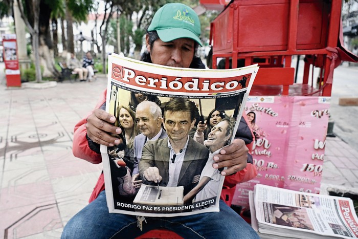 Vendedor de periódicos al día siguiente de la segunda vuelta de las elecciones presidenciales en Tarija, Bolivia, el 20 de octubre. · Foto: Aizar Raldes, AFP