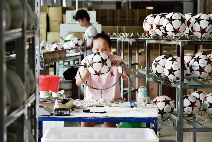 Fábrica de pelotas de fútbol que se exportarán a Rusia y Brasil, en Yiwu. · Foto: AFP, s/d de autor