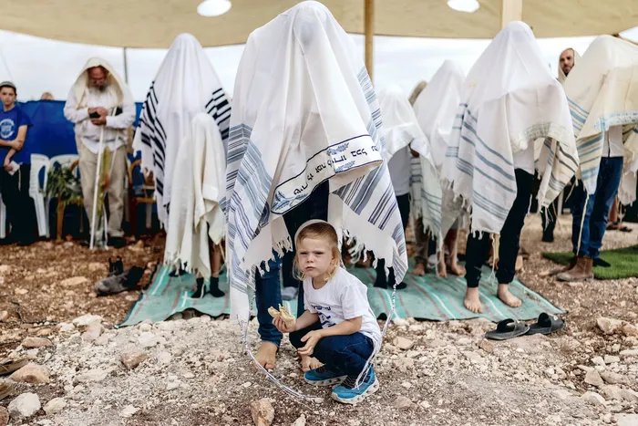 Colonos israelíes rezan en la Cisjordania ocupada, el 30 de setiembre. · Foto: Ilia Yefimovich, AFP