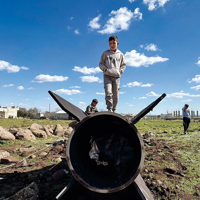 Niños sirios sobre los restos de un cohete iraní en la zona rural de Quneitra, Siria. · Foto: Bakr Alkasem, AFP