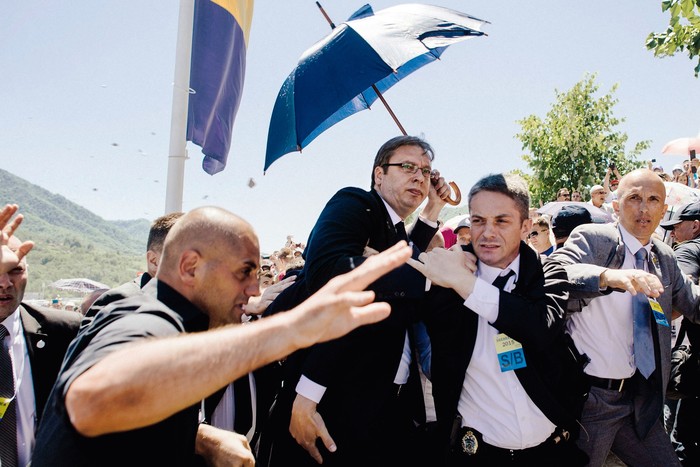 Aleksandar Vučić, junto a sus guardaespaldas, mientras una multitud le lanza piedras cerca de la ciudad de Srebrenica, en el este de Bosnia. · Foto: Dimitar Dilkoff / AFP