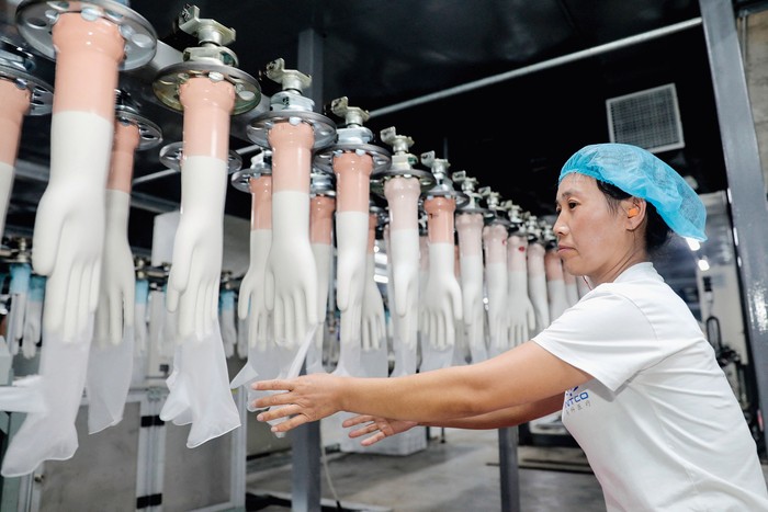 Línea de producción de guantes médicos en una fábrica de Huaibei, en la provincia oriental china de Anhui. · Foto: S/d de autor, AFP