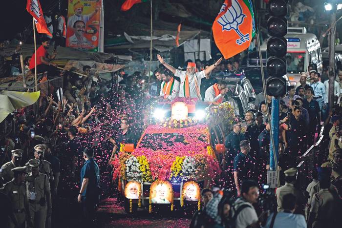 El primer ministro de la India, Narendra Modi (C), saluda a sus seguidores desde lo alto de un vehículo durante un espectáculo en carretera como parte de la campaña electoral del Partido Bharatiya Janata (BJP) antes de las elecciones nacionales en Hyderabad, el 15 de marzo de 2024. · Foto: Noah Seelam, AFP