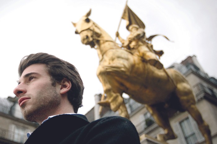 Julien Rochedy frente a una estatua de Juana de Arco, en París. · Foto:  Joel Saget, AFP