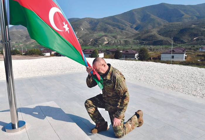 Ilham Aliyev, presidente de Azerbaiyán, con la bandera de su país en Khojaly ciudad principal de Nagorno-Karabaj el 15 de octubre. · Foto: S/d de autor / Presidencia de Azerbaiyán / AFP