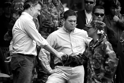 Juan Manuel Santos, presidente colombiano, Juan Camilo Pinzón, ministro de Defensa colombiano, e Irely Collazos Sanchez, cabecilla del Frente de Guerra Suroccidental del ELN, que entregó sus armas el 16 de julio en Cali.  · Foto:  Christian Escobar Mora, Efe