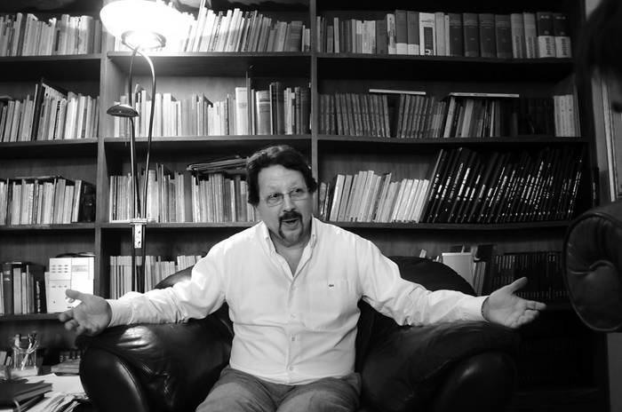 Ricardo Landeira, junta a su biblioteca, durante la entrevista con la diaria.  · Foto: Pablo Nogueira