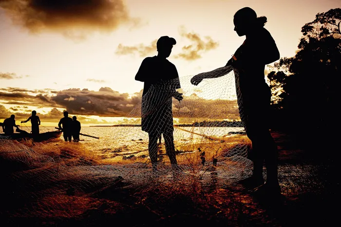 Familia de pescadores en la ciudad de Togoru, a 35 kilómetros de Suva, la capital de Fiyi, antes de la reubicación de su aldea debido al cambio climático. · Foto: Saeed Khan, AFP