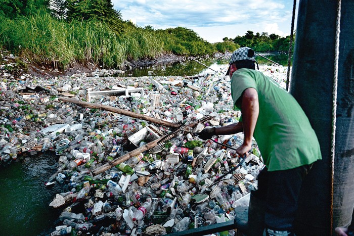 Un miembro de la ONG Marea Verde recoge la basura del río Juan Díaz, en Ciudad de Panamá, el 1º de octubre de 2024. · Foto: Martin Bernetti / AFP
