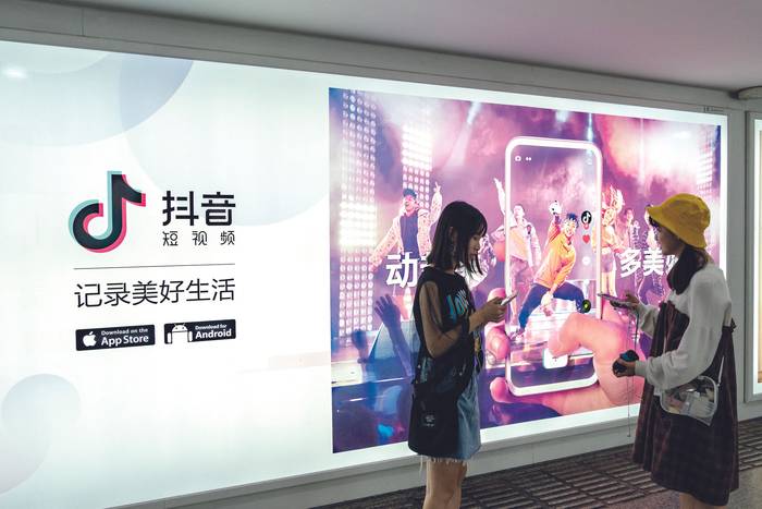 Peatones frente a un anuncio de TikTok en Shanghái, China, julio de 2018. · Foto: Imaginechina / AFP