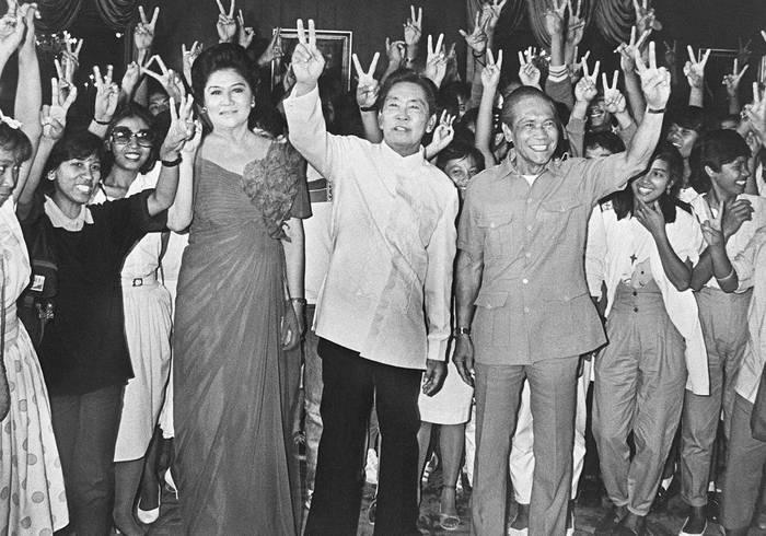 Ferdinand Marcos (centro) como presidente de Filipinas, su esposa Imelda y su vicepresidente, Arturo Tolentino, el 16 de febrero de 1986, en Manila. · Foto: HO / AFP