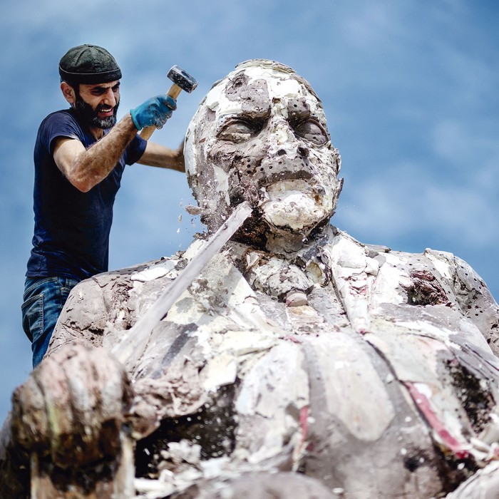 Khaled Dawwa, escultor sirio exiliado, destruye su gigantesca obra de arte “El rey de los agujeros” como protesta frente a las oficinas de las Naciones Unidas en Ginebra, el 30 de agosto. · Foto: Fabrice Coffrini, AFP