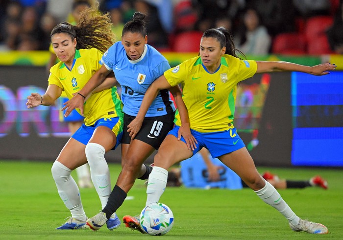 La uruguaya Wendy Carballo entre las brasileñas Angelina Alonso y Antonia, el 29 de julio, en el estadio Rodrigo Paz Delgado, en Quito. · Foto: Rodrigo Buendía, AFP