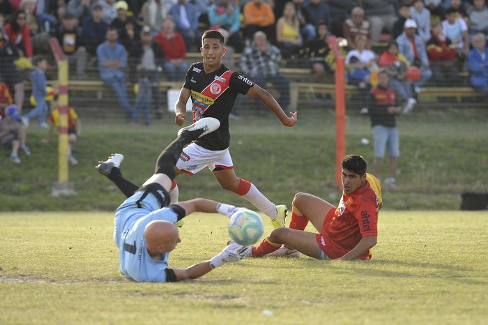 Matias Quintana y Jonathan Rios de Villa Española y Cristian Olivera de Rentistas, en el estadio Obdulio Varela, el 7 de diciembre · Foto: Federico Gutiérrez