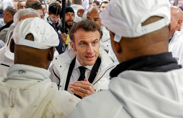 Emmanuel Macron con trabajadores durante una visita al Mercado Internacional de Rungis, en París (21.02.2023). · Foto: Benoit Tessier, AFP