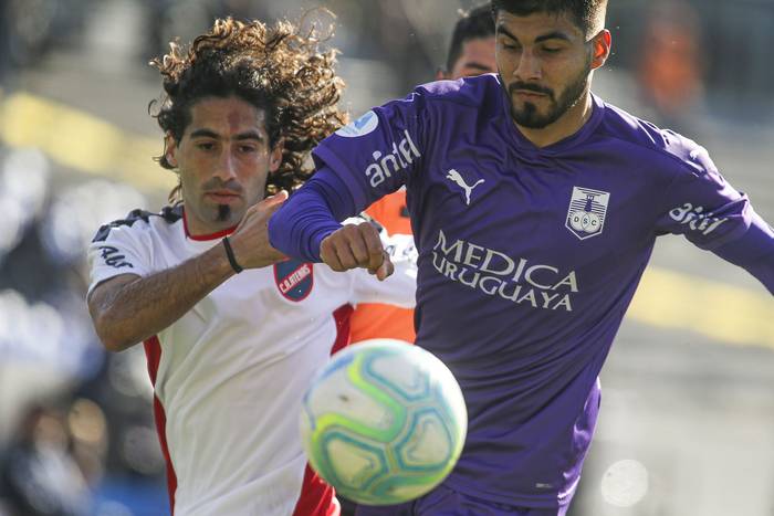 Matias Britos, de Atenas, y Renzo Rabino, de Defensor Sporting, este jueves, en el estadio Charrúa. · Foto: .