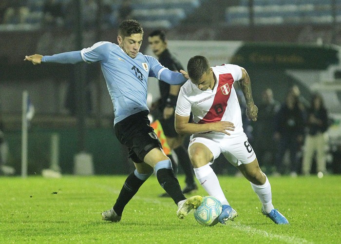 Maximiliano Gómez, de Uruguay, y Carlos Zambrano, de Perú, en el estadio Centenario. · Foto: .