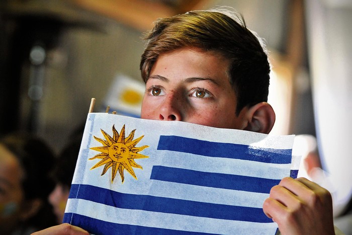 Un niño mira el partido entre Uruguay y Arabia Saudita en Piedras de Afilar, Canelones, donde el
partido se proyectó para escolares, autoridades de la educación y vecinos en un galpón.
 · Foto: Federico Gutiérrez