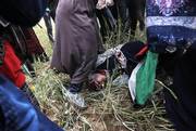 Una mujer palestina herida yace en el suelo durante los enfrentamientos con las fuerzas de seguridad israelíes tras una manifestación conmemorativa del Día de la Tierra, cerca de la frontera con Israel, al este de Khan Yunis, en el sur de la Franja de Gaza, el 30 de marzo de 2018. / AFP PHOTO / SAID KHATIB