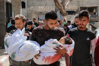 Los hermanos (centro y derecha) de Zain Hijazi, un niño de cuatro años, caminan con el cuerpo tras su muerte en un campamento para palestinos desplazados que fue alcanzado por un bombardeo israelí, el 21 de abril, en la ciudad de Gaza. · Foto: Omar Al-Qattaa, AFP