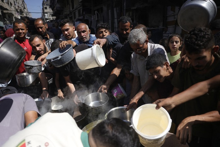 Palestinos hacen fila para recibir una comida caliente en un punto de distribución de alimentos,  el 27 de junio, en la ciudad de Gaza. · Foto: Bashar Taleb, AFP