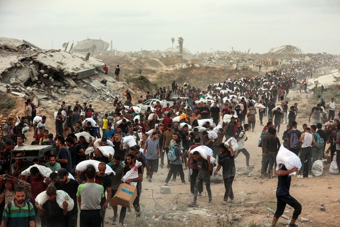 Palestinos con alimentos caminan por un sendero costero, el 29 de julio, al oeste de Beit Lahia. · Foto: Omar Al-Qattaa, AFP