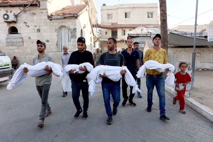 Hombres palestinos cargan los cuerpos de niños asesinados el 2 de julio en un ataque israelí en la ciudad de Gaza. · Foto: Omar Al-Qattaa, AFP