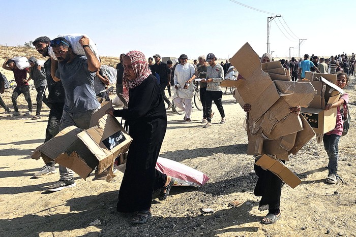 Palestinos desplazados caminan por una carretera para recibir paquetes de ayuda humanitaria de una fundación respaldada por Estados Unidos, el 5 de junio, en Rafah, al sur de la Franja de Gaza. · Foto: AFP