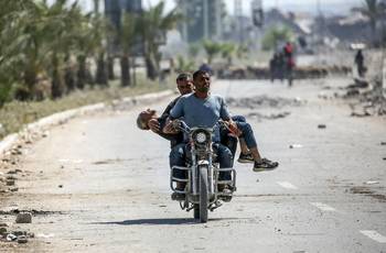 Un hombre que recibió un disparo mientras buscaba alimento en un punto de distribución es trasladado, el 27 de julio, al campo de refugiados de Bureij, en el centro de la Franja de Gaza. · Foto: Eyad Baba, AFP