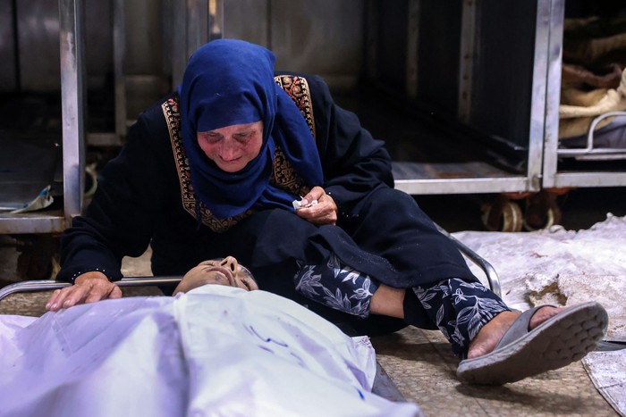 Una mujer palestina llora junto al cuerpo de un familiar fallecido, el 30 de junio, en un ataque israelí contra la cafetería Al-Baqa, en el paseo marítimo de la ciudad de Gaza. · Foto: Omar Al-Qattaa, AFP