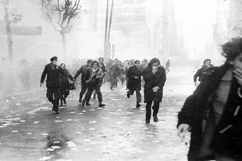 Manifestantes huyen de los gases arrojados por la Policía, el 9 de julio de 1973, en el Centro de Montevideo. · Foto: Aurelio González