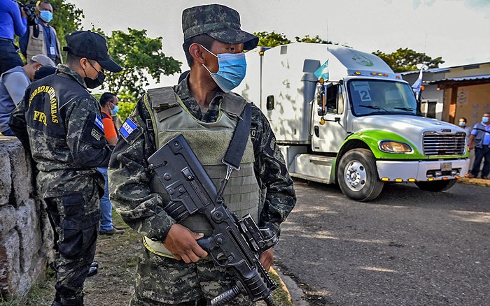 Soldados custodian los camiones que distribuyen material electoral, este 23 de noviembre, en Tegucigalpa. · Foto: Orlando Sierra, AFP