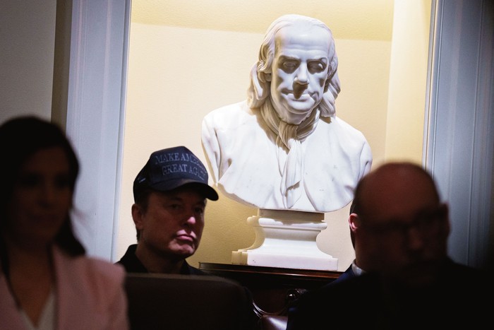 Elon Musk junto a una estatua de Benjamin Franklin, durante una reunión del gabinete de gobierno, el 26 de febrero en Washington DC. · Foto: Andrew Harnik, Getty Images, AFP