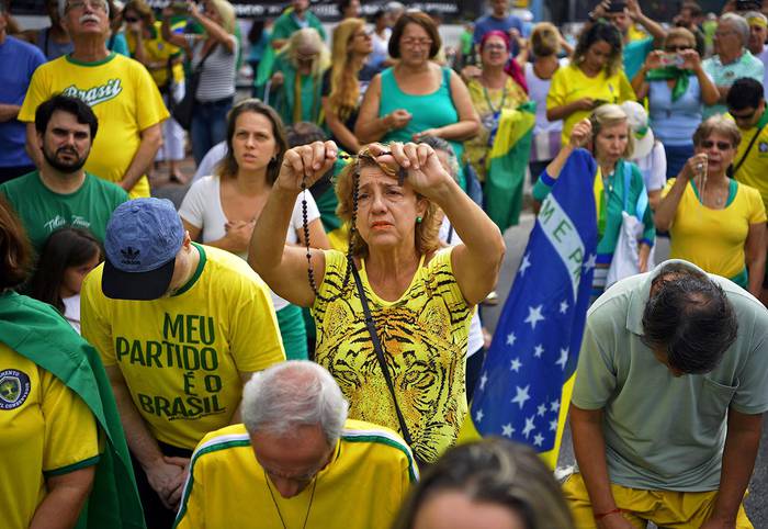 Partidarios del presidente de Brasil Jair Bolsonaro rezan durante una manifestación de apoyo a su gobierno, ayer, en Río de Janeiro. · Foto: Carl de Souza, AFP
