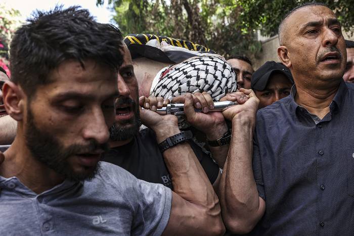 Palestinos llevan el cuerpo de un hombre asesinado en una redada militar israelí en Yenín, en la Cisjordania ocupada (19.06.2023). · Foto: Ronaldo Schemidt, AFP