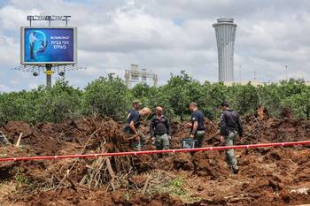 Miembros de seguridad israelíes inspeccionan un cráter cerca de una carretera en las afueras del aeropuerto Ben Gurión de Israel, el 4 de mayo, después de un ataque con misil lanzado desde Yemen. · Foto: Jack Guez, AFP