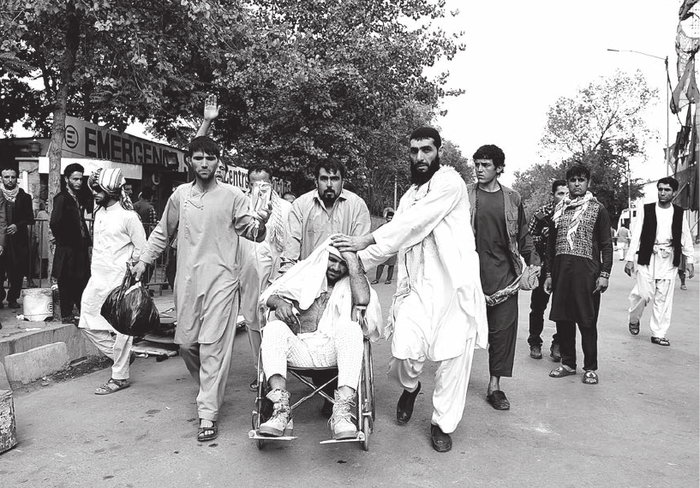 Familiares trasladan a un herido fuera de un hospital, tras una serie de explosiones en Kabul, el sábado. * Foto: Wakil Kohsar, AFP.