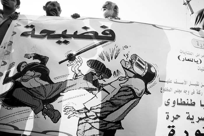 Manifestantes portan un cartel en el que se muestra a una heroina de comic llamada Blue Bra dandole una patada a un soldado bajo
la palabra gescandaloh, en arabe, durante un acto de protesta contra la junta militar que gobierna Egipto, ayer, en la plaza Tahrir en El
Cairo. · Foto: Efe, Khaled Elfoqi