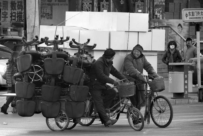 Dos chinos hacen sus entregas en triciclo debido a las restricciones de transporte en vigor durante el dia en Pekin, ayer.
 · Foto: Efe, Adrian Bradshaw
