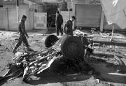 Agentes de las fuerzas de seguridad de Irak inspeccionan los restos calcinados de un coche en el escenario de un atentado suicida con coche bomba en Kirkuk. 