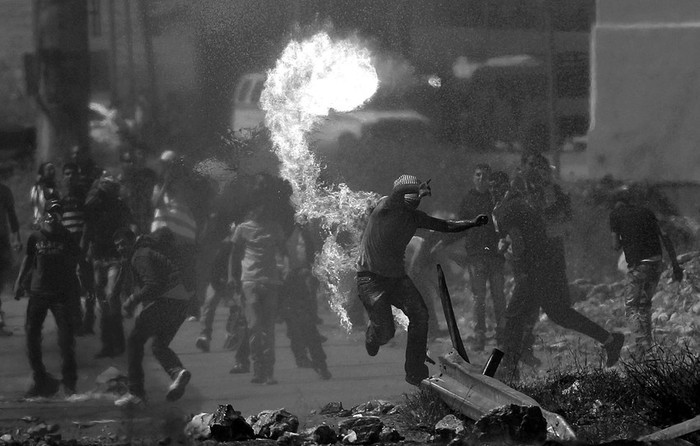 Palestinos durante un enfrentamiento con soldados israelíes en el punto fronterizo de Bitwonia, a las afueras de la prisión israelí de Ofer.
 · Foto: Efe, Atef Safadi