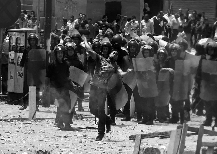 Un hombre tira piedras a manifestantes antimilitares durante los disturbios en el barrio de Abbassiya, El Cairo, Egipto. · Foto: Efe, Khaled Elfoqi