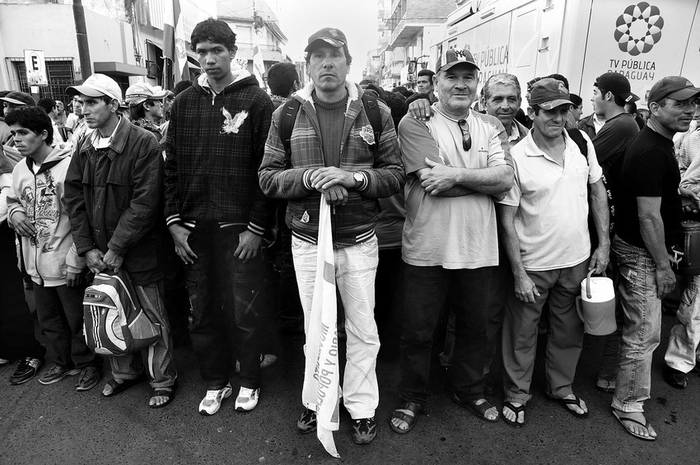 Militantes del Movimiento Agrario Campesino (MAP), durante una reunión de delegados para resolver las posiciones a llevar a una asamblea de la concentración opositora al nuevo presidente Federico Franco,
frente a la sede de Televisión Pública, en Asunción, Paraguay. · Foto: Sandro Pereyra