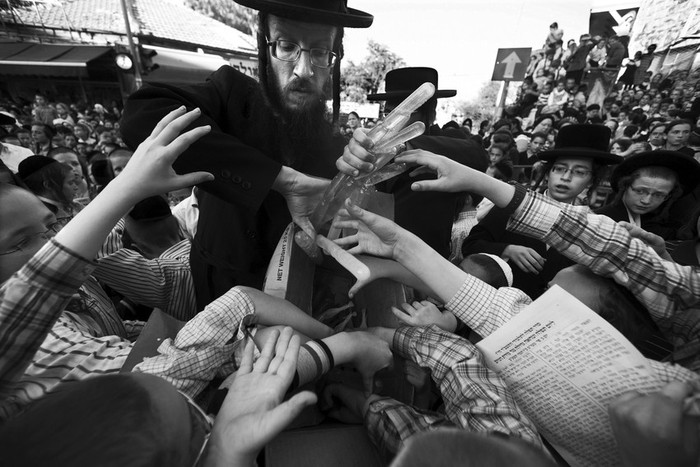 Un profesor reparte juguetes de agua a un grupo de niños judíos ultraortodoxos que se manifiestan en Jerusalén contra la modificación de la ley que exime del servicio militar obligatorio
a los judíos ultraortodoxos y a la minoría árabe.  · Foto: EFE, Jim Hollander 
