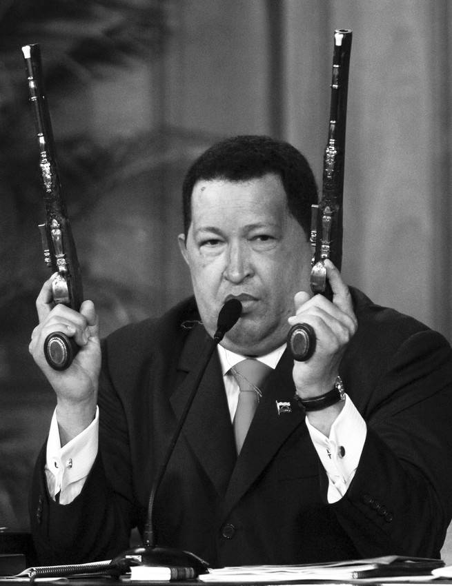 El presidente venezolano, Hugo Chávez, sostiene dos pistolas
que pertenecieron a Simón Bolívar durante un acto en el que el
mandatario desveló una imagen digitalizada del rostro del héroe
nacional, para conmemorar el 229º aniversario de su natalicio, en el
Palacio de Miraflores en Caracas. · Foto: Efe, David Fernández